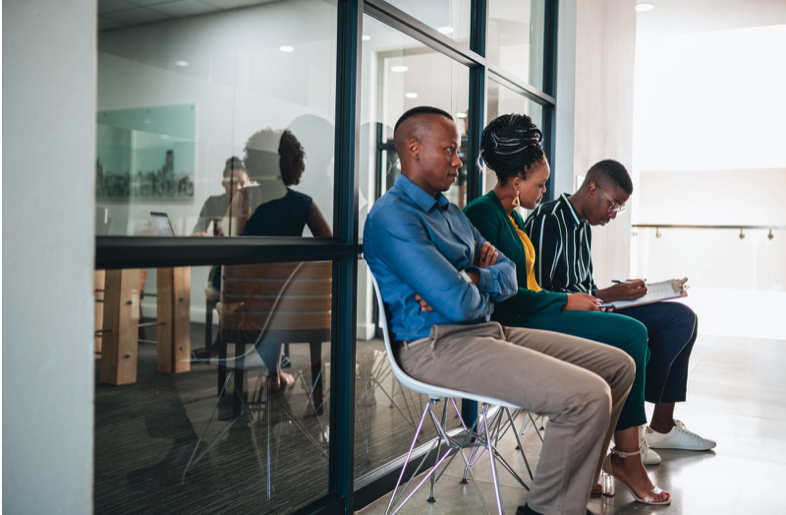 Three young Black professionals preparing to be interviewed for a job
