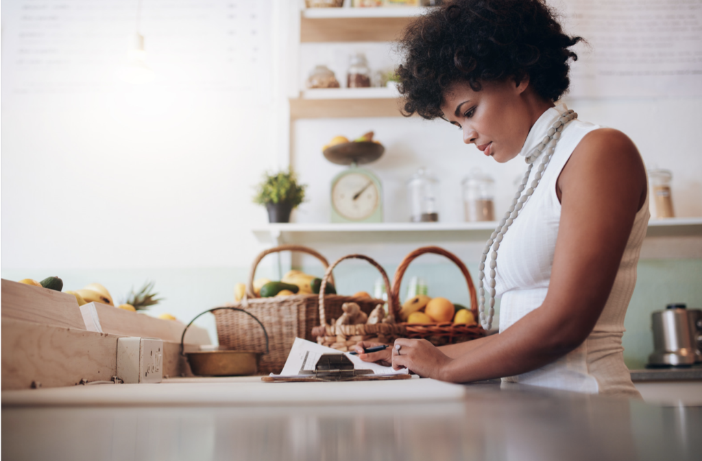 female juice bar owner reading small business loan requirements